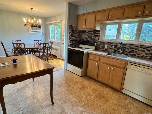 kitchen with white appliances, sink, an inviting chandelier, radiator heating unit, and hanging light fixtures