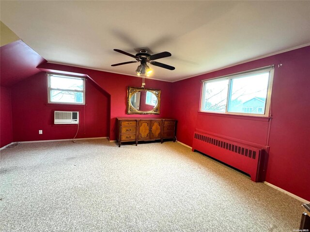 interior space featuring radiator, light carpet, a healthy amount of sunlight, and vaulted ceiling