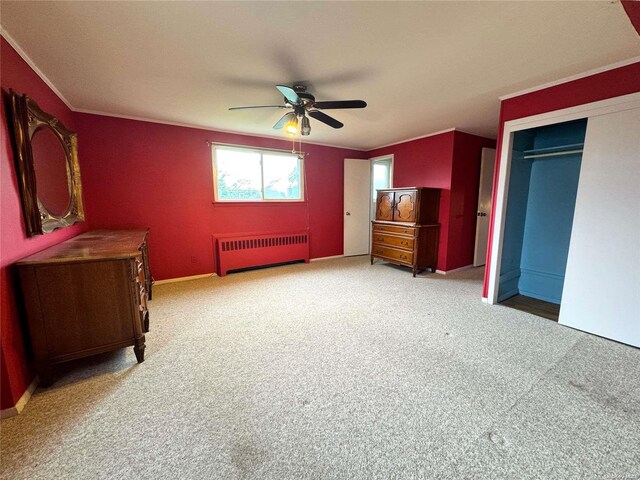 unfurnished bedroom featuring carpet, radiator heating unit, a closet, and ceiling fan