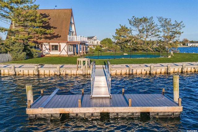 dock area featuring a balcony, a yard, and a water view