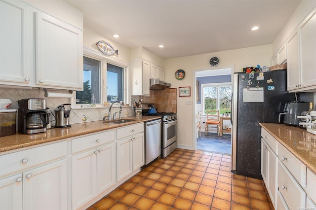 kitchen with appliances with stainless steel finishes, backsplash, white cabinetry, and sink