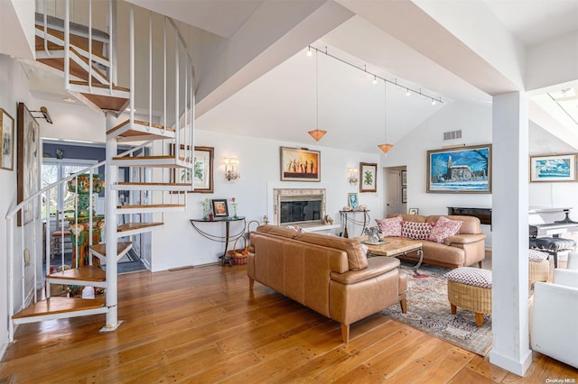 living room featuring hardwood / wood-style floors, rail lighting, and high vaulted ceiling