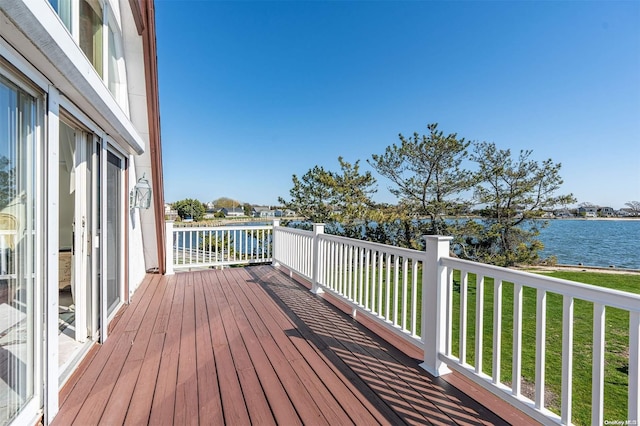 wooden deck featuring a lawn and a water view