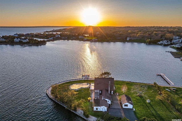 aerial view at dusk featuring a water view