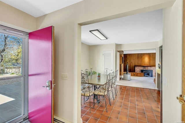 carpeted dining area featuring a wood stove and a baseboard heating unit