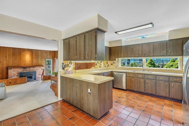 kitchen featuring carpet flooring, a wealth of natural light, sink, stainless steel appliances, and kitchen peninsula