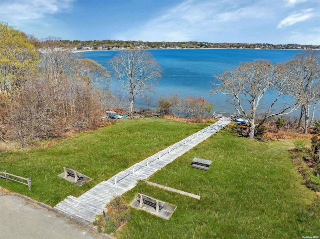 view of home's community with a water view and a yard