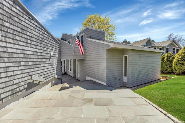 back of property with a patio area and a yard