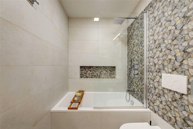 bathroom with tiled shower / bath combo and toilet