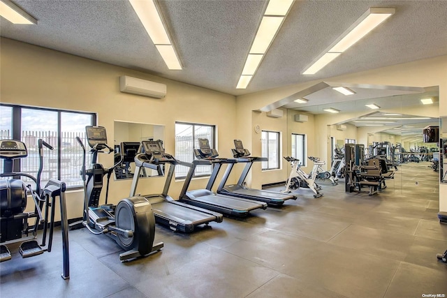 gym featuring a wall mounted air conditioner and a textured ceiling