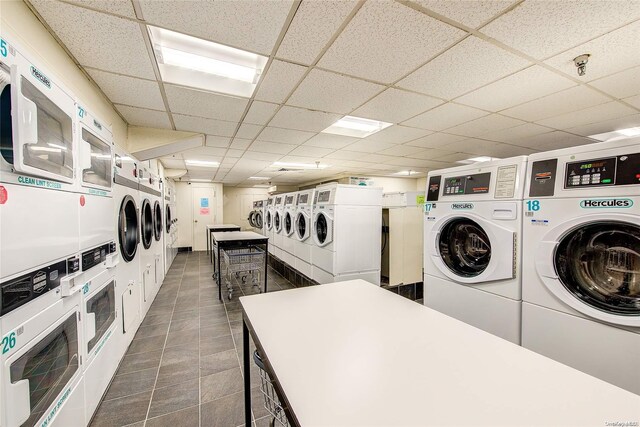 laundry room with washer and dryer, dark tile patterned floors, and stacked washer / dryer