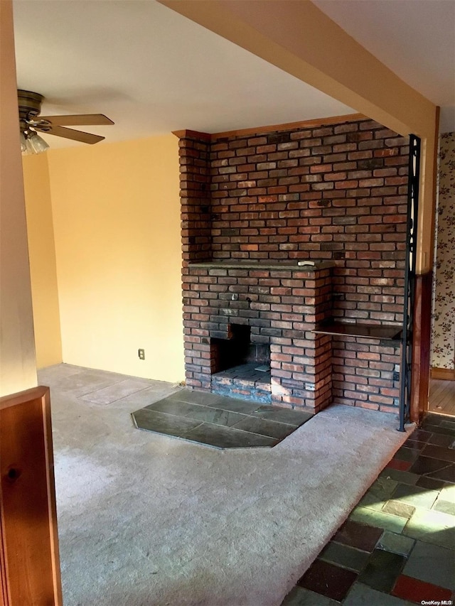 unfurnished living room with a fireplace, carpet flooring, and ceiling fan