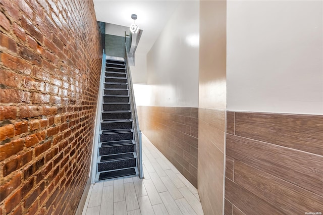 stairway with tile walls and brick wall