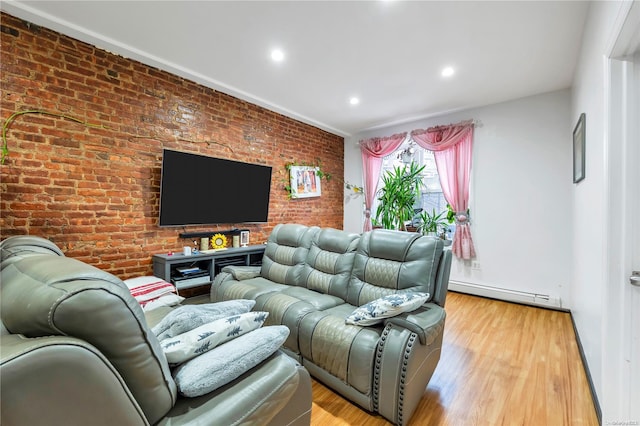 living room featuring baseboard heating, light hardwood / wood-style floors, and brick wall