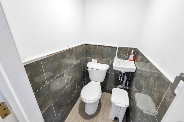 bathroom with tile walls and toilet