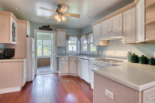 kitchen with white appliances, sink, hardwood / wood-style flooring, ceiling fan, and kitchen peninsula