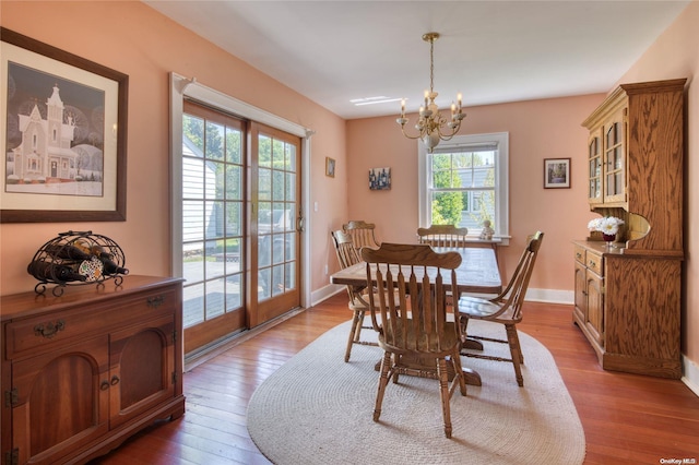 dining area featuring light hardwood / wood-style flooring and a notable chandelier