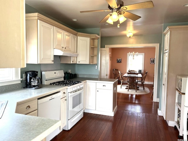 kitchen with kitchen peninsula, dark hardwood / wood-style flooring, white appliances, ceiling fan with notable chandelier, and cream cabinets