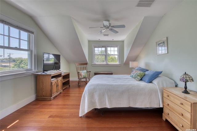 bedroom with multiple windows, ceiling fan, light hardwood / wood-style floors, and lofted ceiling