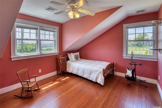 bedroom with hardwood / wood-style flooring, multiple windows, lofted ceiling, and ceiling fan