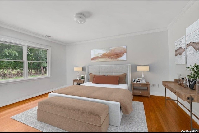 bedroom with ornamental molding and dark hardwood / wood-style flooring