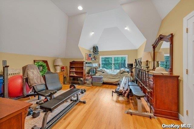 workout area featuring wood-type flooring and vaulted ceiling