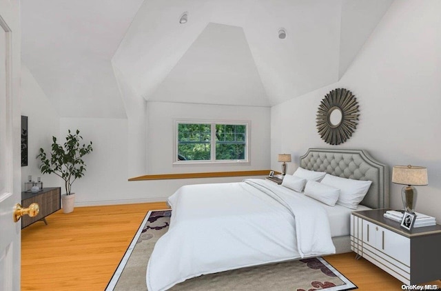 bedroom with lofted ceiling and hardwood / wood-style floors