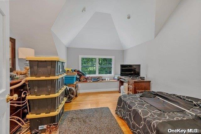 bedroom with vaulted ceiling and light hardwood / wood-style floors