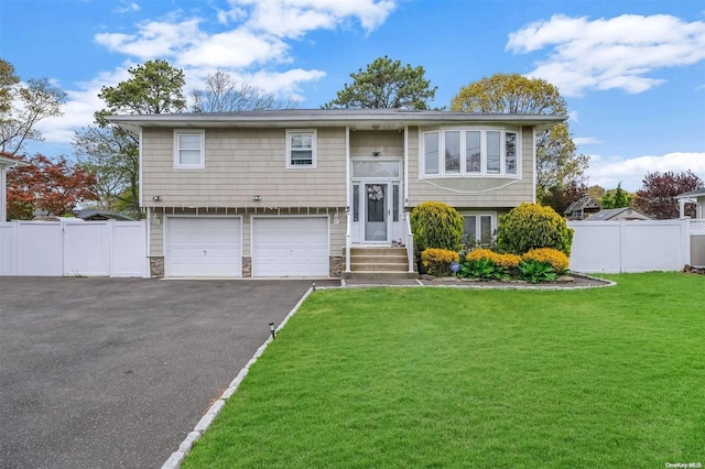 bi-level home featuring a garage and a front yard