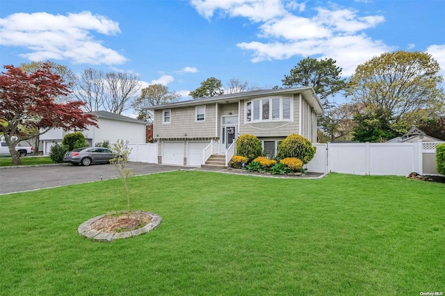 split foyer home featuring a garage and a front yard