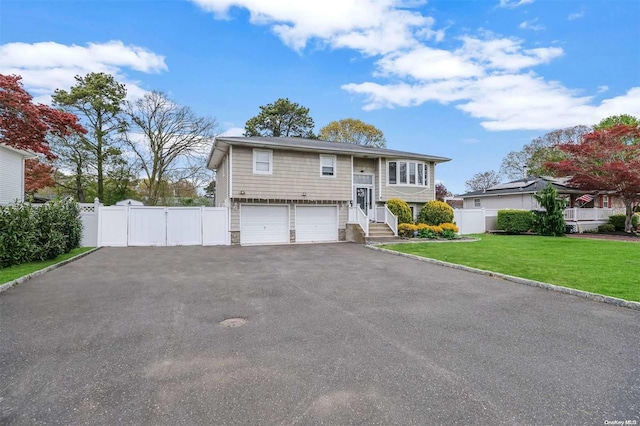 bi-level home featuring a garage and a front yard