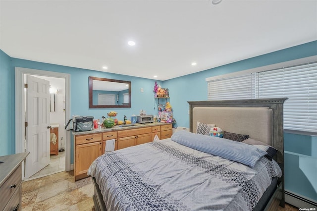 bedroom featuring a baseboard heating unit and connected bathroom