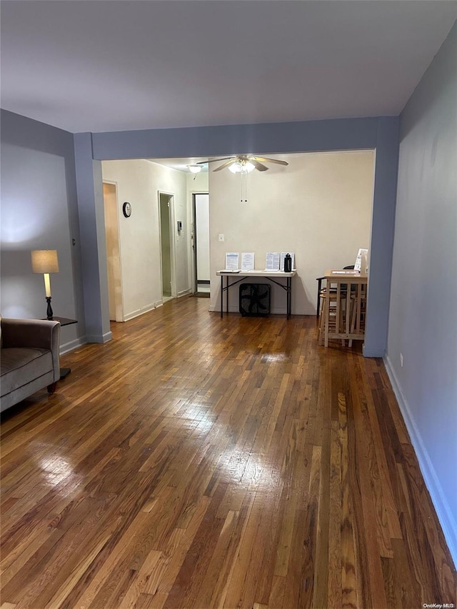 unfurnished living room with ceiling fan, dark hardwood / wood-style flooring, and baseboard heating