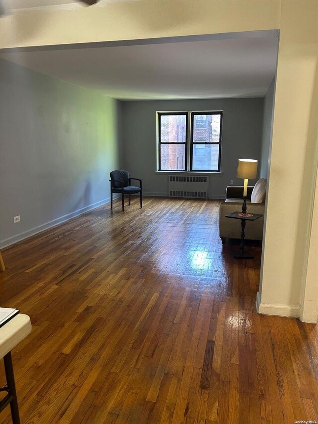 unfurnished room featuring dark hardwood / wood-style flooring and radiator