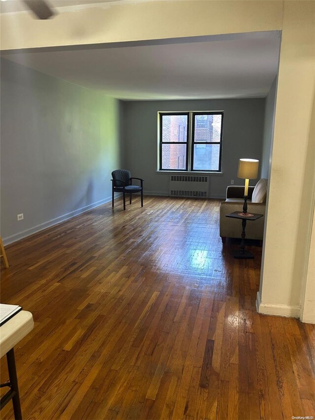 sitting room featuring radiator heating unit and dark wood-type flooring