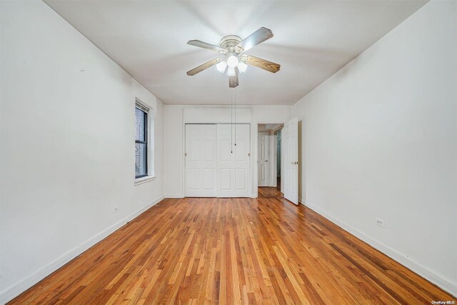 unfurnished bedroom featuring a closet, light hardwood / wood-style flooring, and ceiling fan