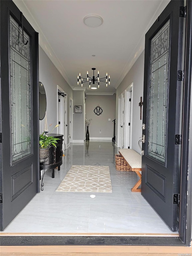 entryway with a chandelier and crown molding