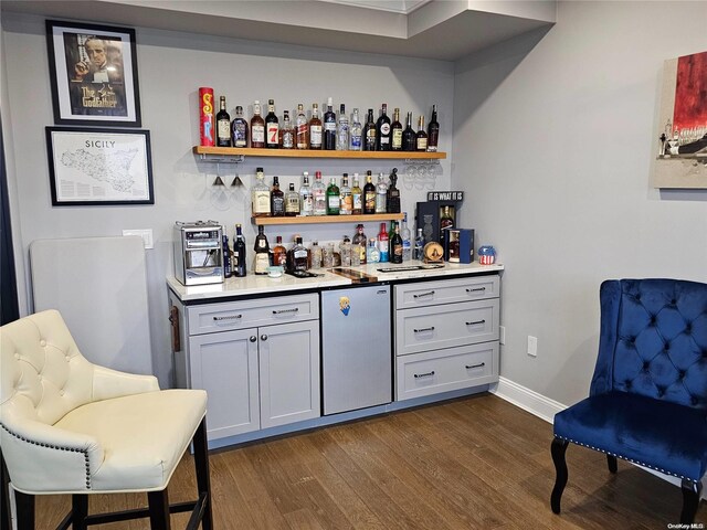 47 Pershing Ave, Babylon, NY 11702 - indoor dry bar with dark wood-type flooring, fridge, and baseboards