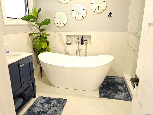 47 Pershing Ave, Babylon, NY 11702 - bathroom featuring tile walls, a freestanding tub, vanity, and a wainscoted wall