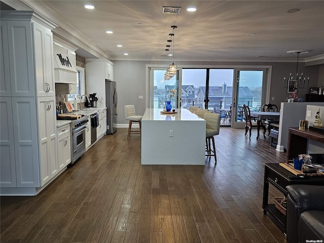 47 Pershing Ave, Babylon, NY 11702 - kitchen featuring stainless steel appliances, a kitchen island, a kitchen breakfast bar, dark wood-style flooring, and white cabinets