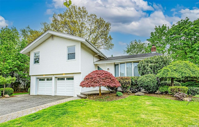 tri-level home featuring a front lawn and a garage