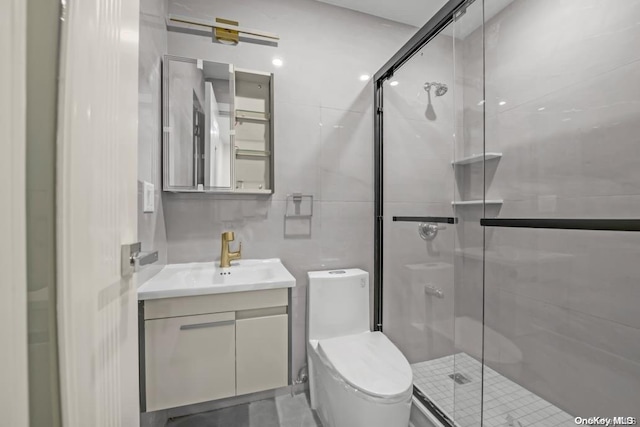 bathroom with vanity, toilet, and a shower with shower door