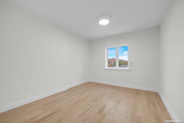 empty room with vaulted ceiling and light hardwood / wood-style flooring