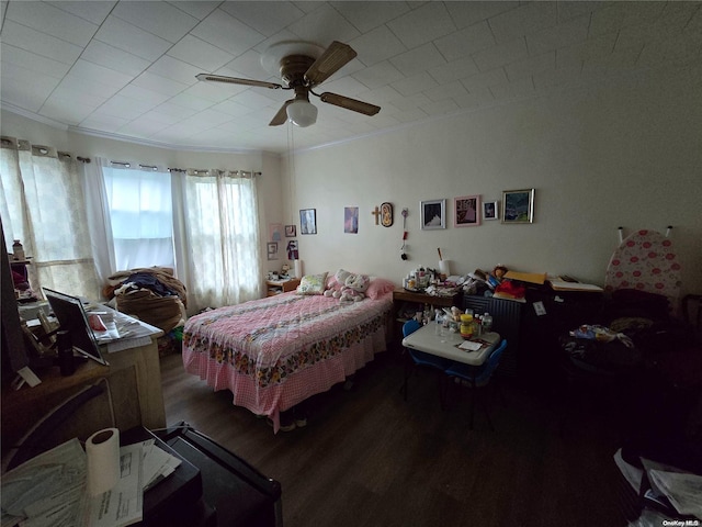 bedroom featuring ceiling fan, crown molding, and hardwood / wood-style flooring