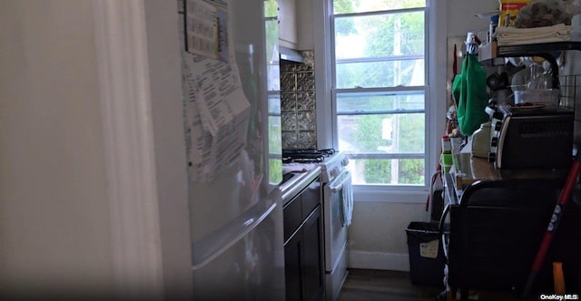 kitchen with refrigerator, hardwood / wood-style floors, and white gas range