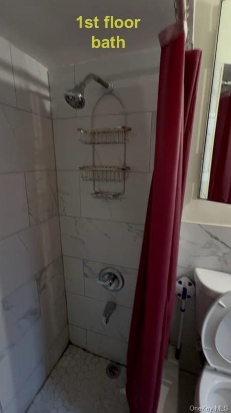 bathroom with tile walls and toilet