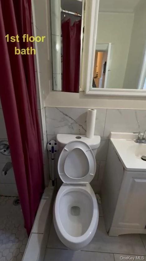 bathroom featuring tile patterned flooring, backsplash, curtained shower, and toilet