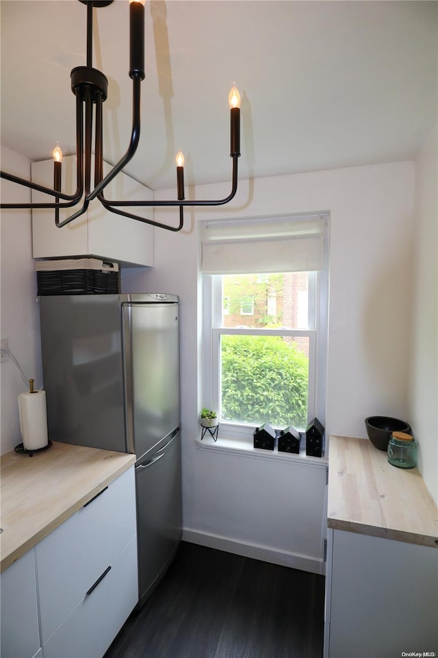 kitchen featuring dark hardwood / wood-style flooring, decorative light fixtures, white cabinetry, and high end fridge