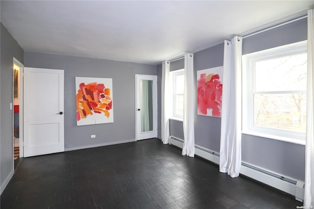 unfurnished room featuring dark wood-type flooring, a healthy amount of sunlight, and a baseboard radiator