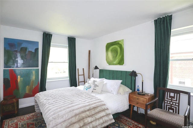 bedroom featuring multiple windows and dark wood-type flooring